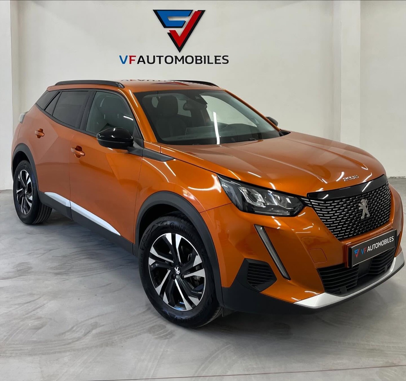 Peugeot 2008 orange exposée dans le showroom VF Automobiles